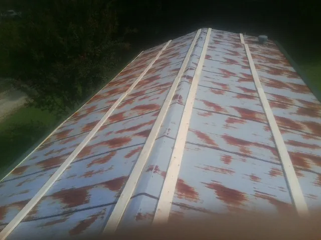 Rusted metal roof panels with new wood purlins before replacement — Storm Damage Roof Repair in Emory by Roofing Brothers
