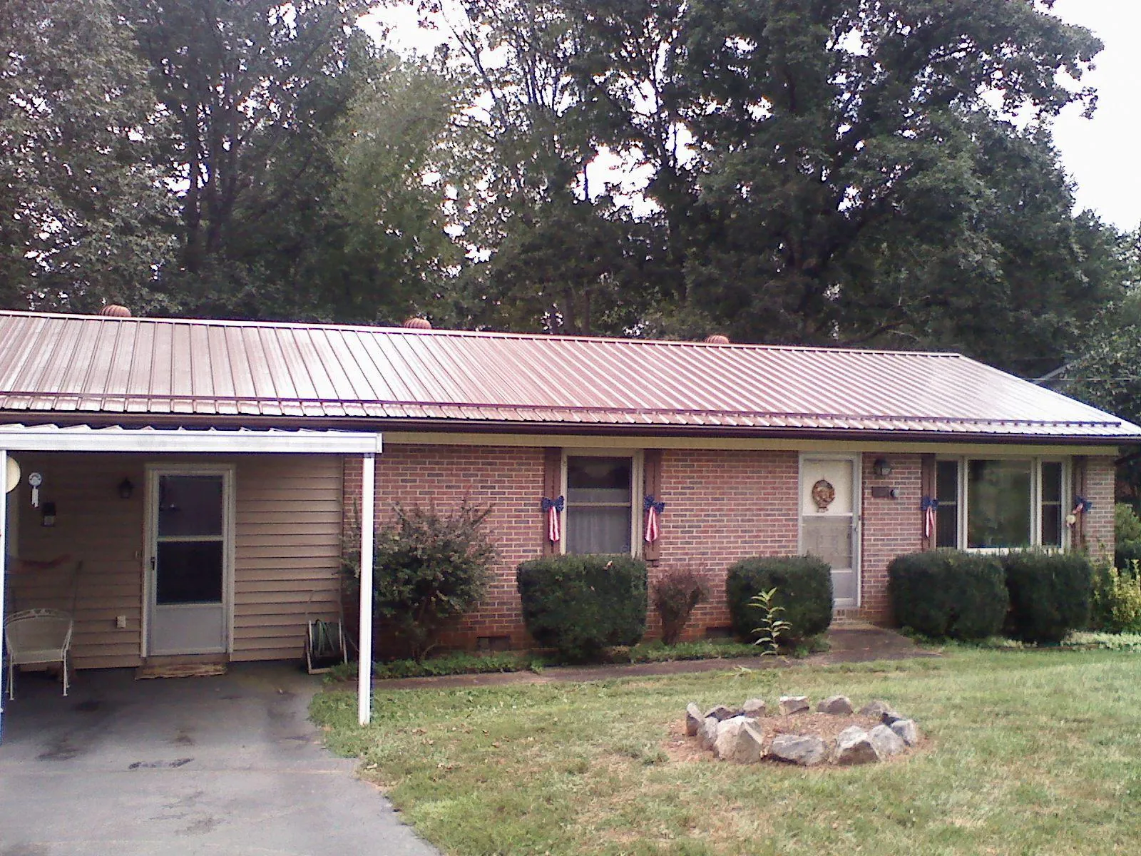 Bronze metal roof and carport on a brick ranch home — Roof Repair work by our crew in Emory